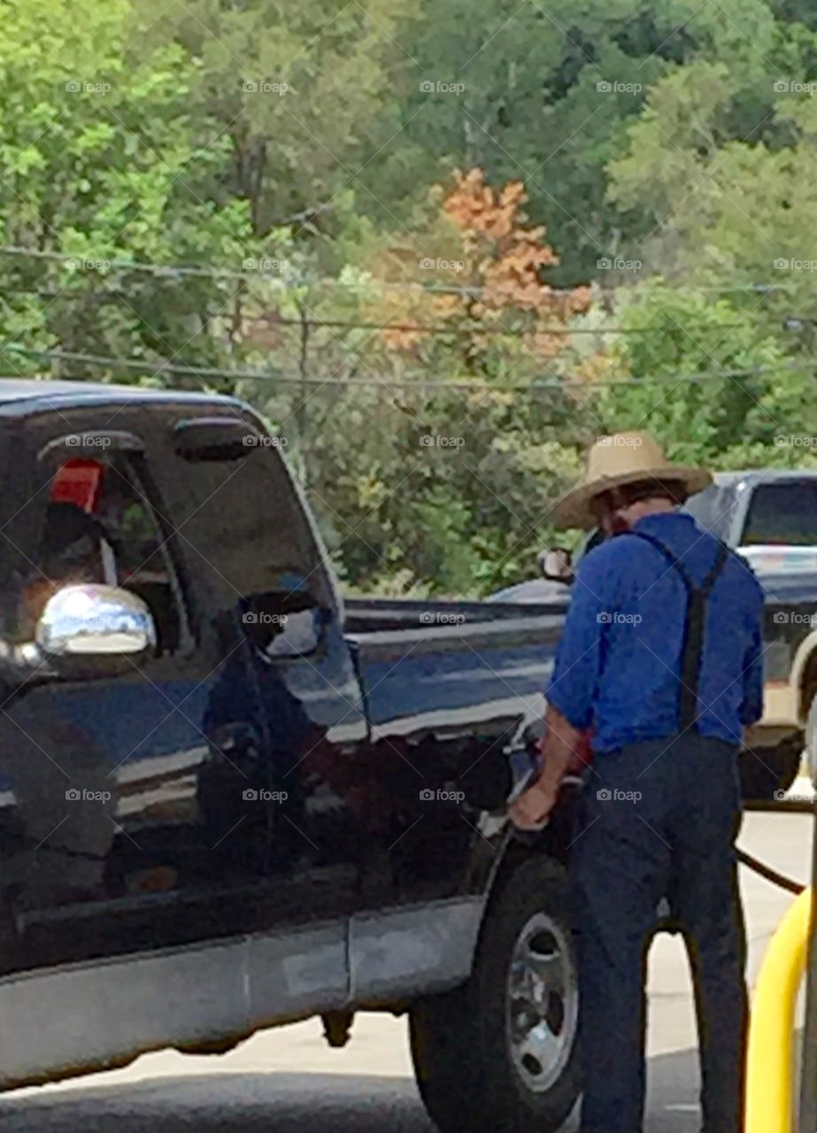 An Amish man getting gas for the driver in New York.