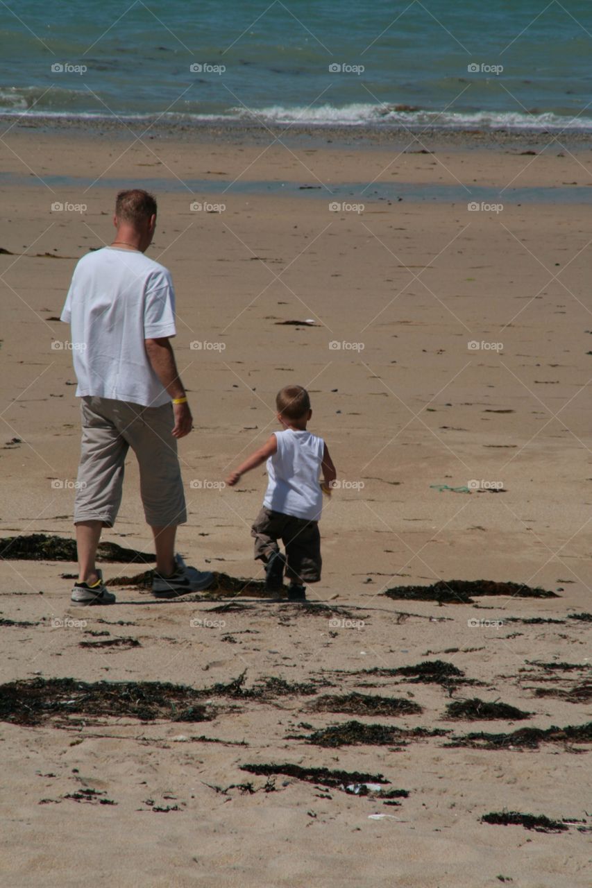 Father and Son walking down the beach