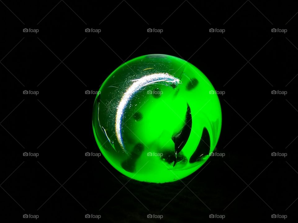 Glass ball illuminated with green light.