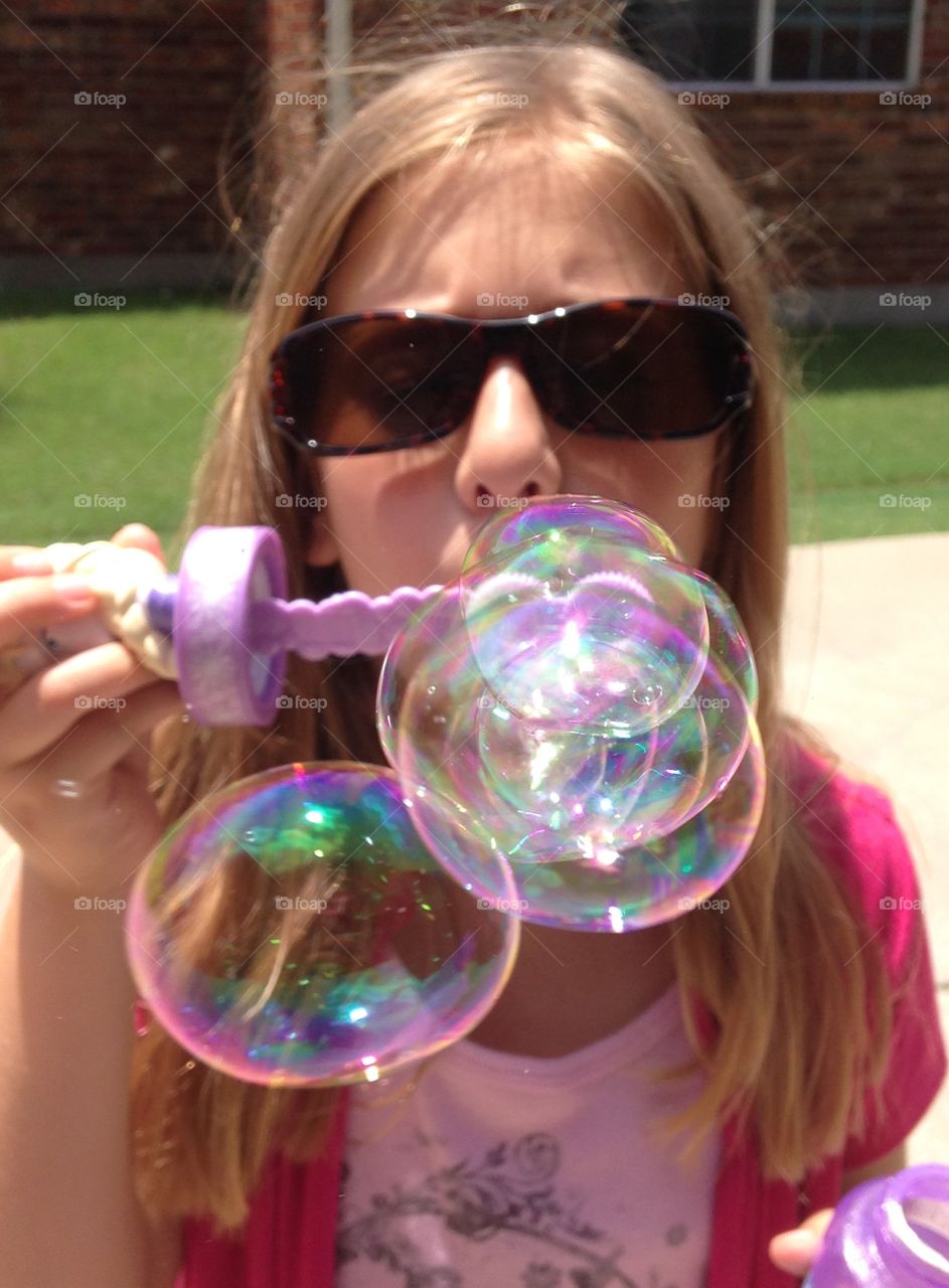 Ready or not, here they come!. Girl blowing bubbles at the camera 