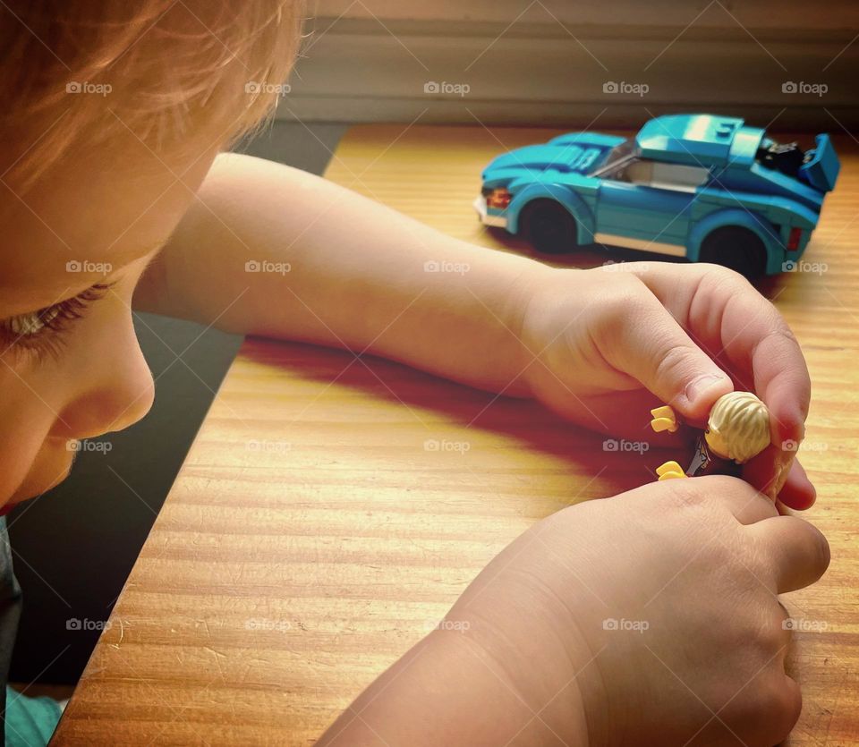 A young child has fun playing and being creative with Legos on a rainy day