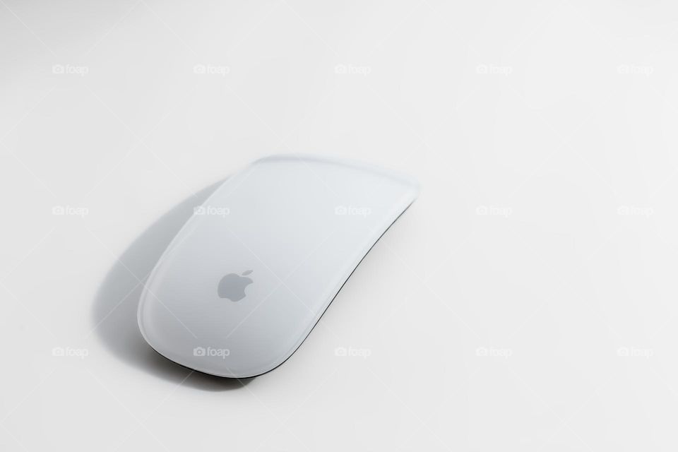 Wireless Apple mouse on off white background 