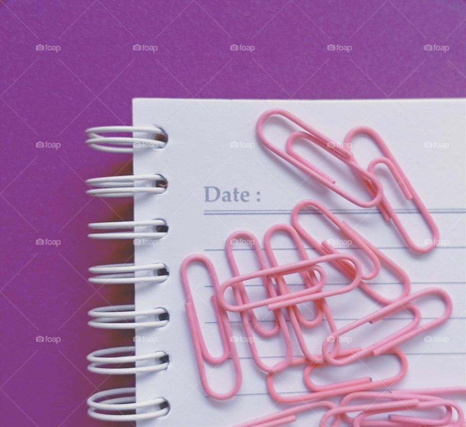 Paper clips on a book with purple color as background...