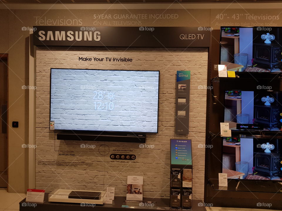Samsung QLED 4K UHD TV displaying ambient mode wall mounted television with all-in-one upfiring soundbar at Peter Jones Sloane square Chelsea King's road London