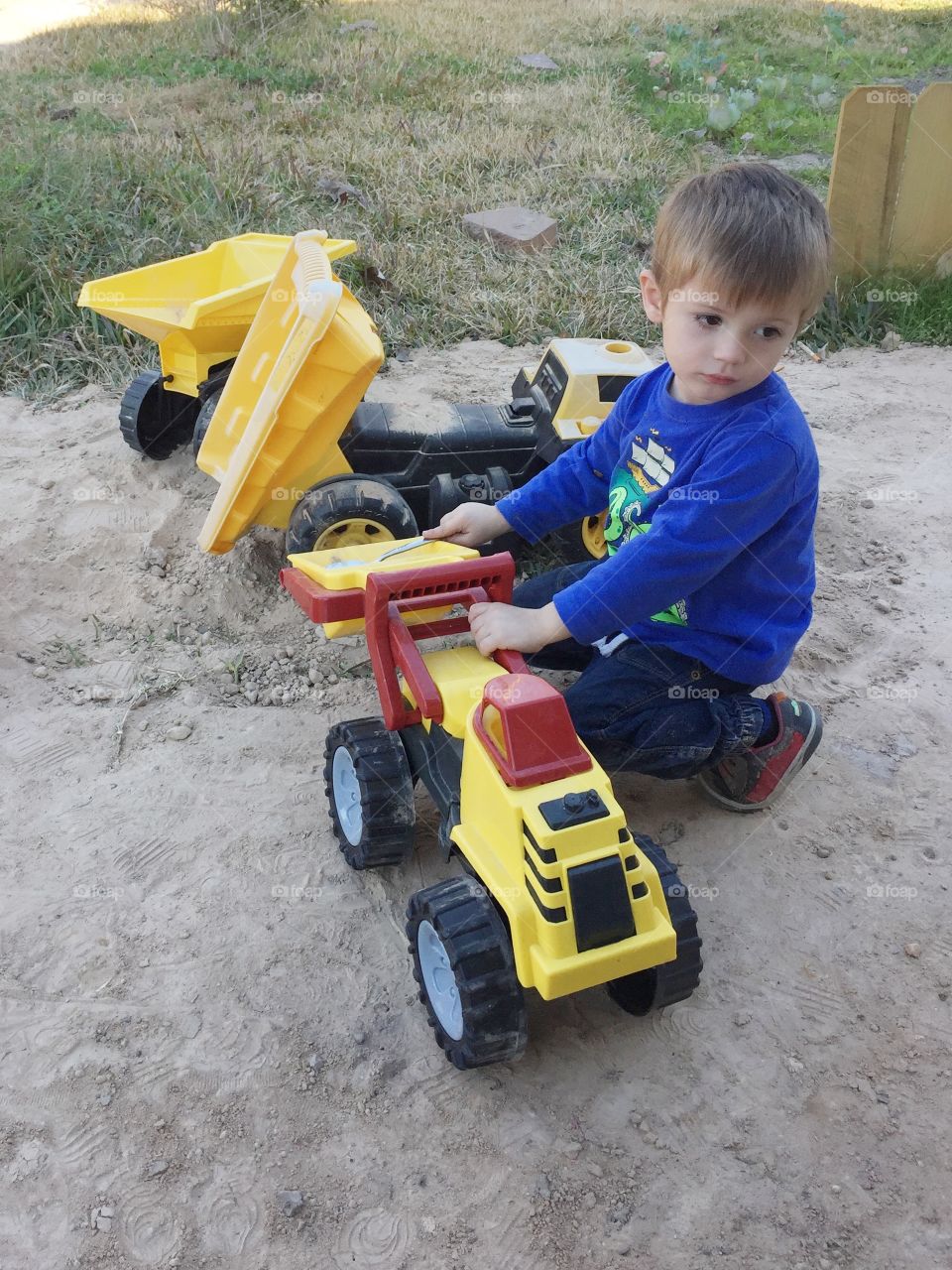 Grandson playing with his trucks outside and having fun