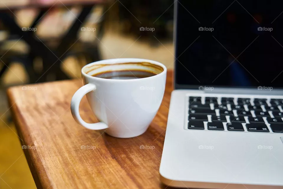 Black coffee in a table next to the laptop