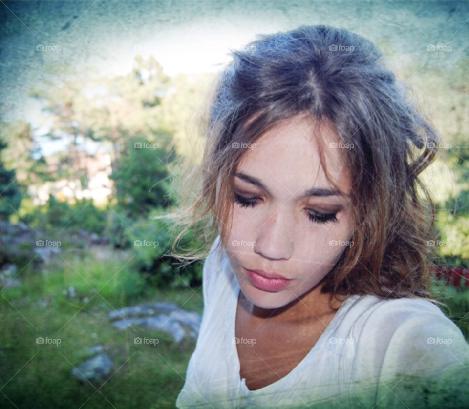 A young girls face. A close up photo of a young girl looking down