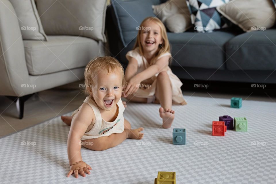 Happy siblings having fun at home