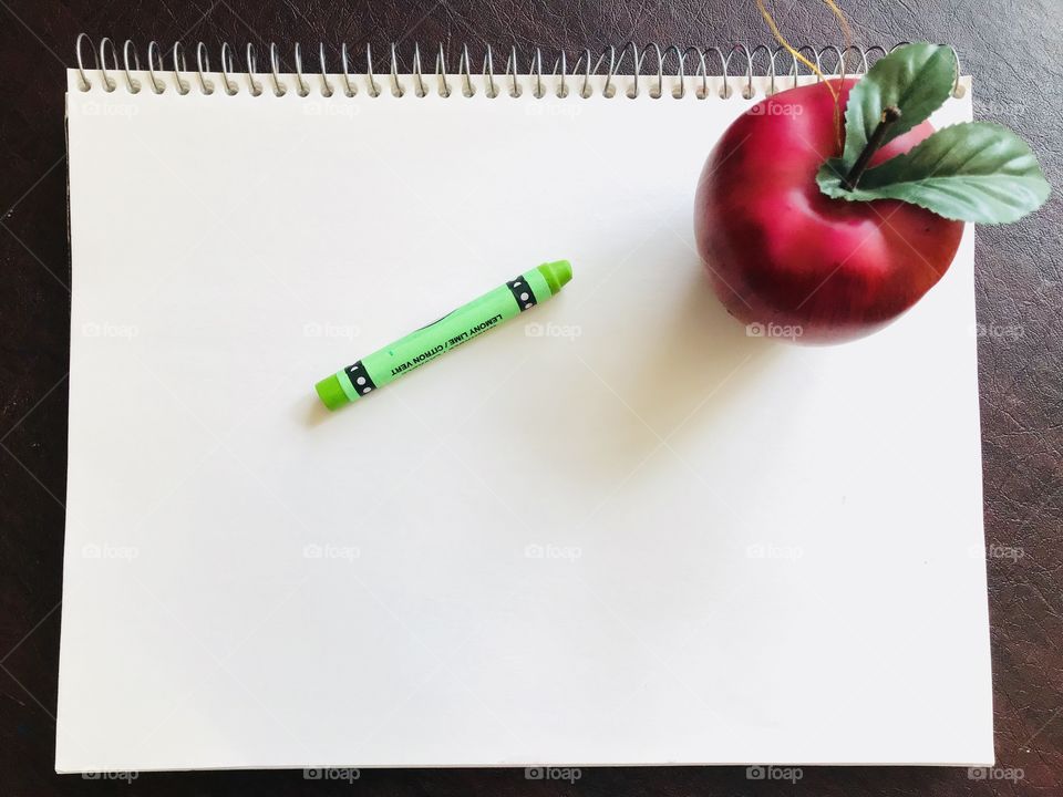 Notepad with crayon and Apple 