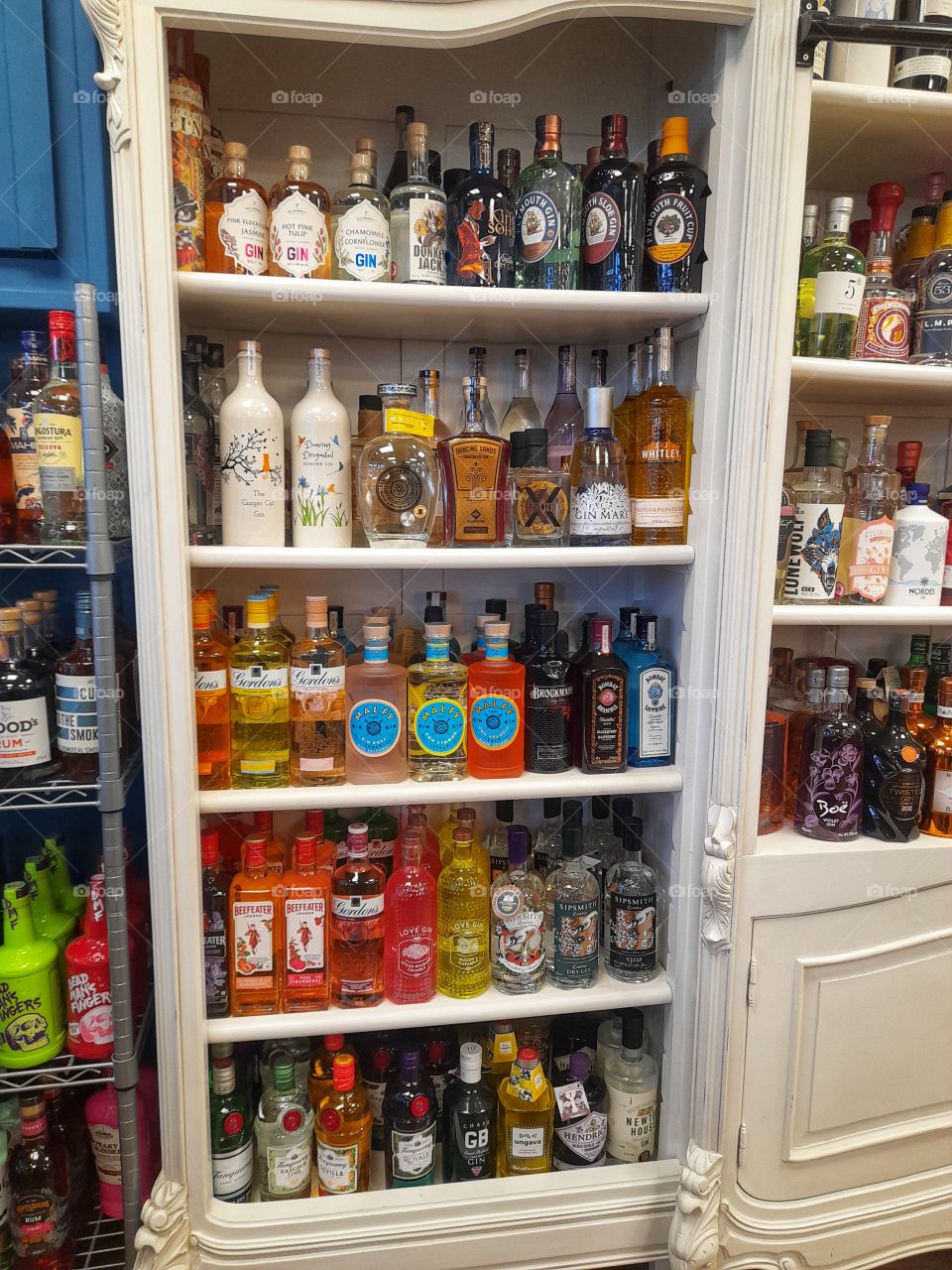 Variety of we'll-known brands of gin on shelf.