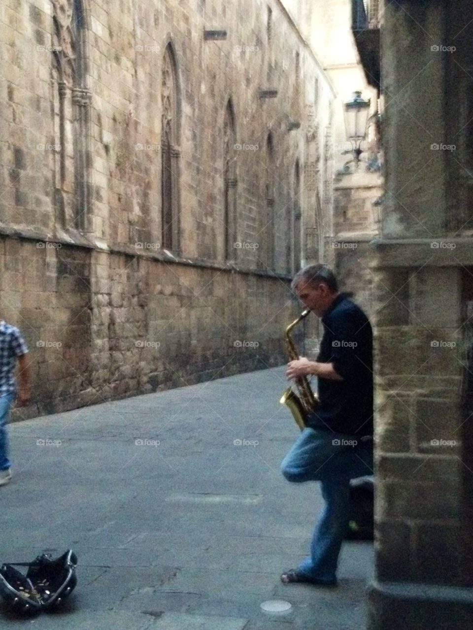 Saxophone player. Saxophone player standing in a corner of an old stone house in Barcelona 