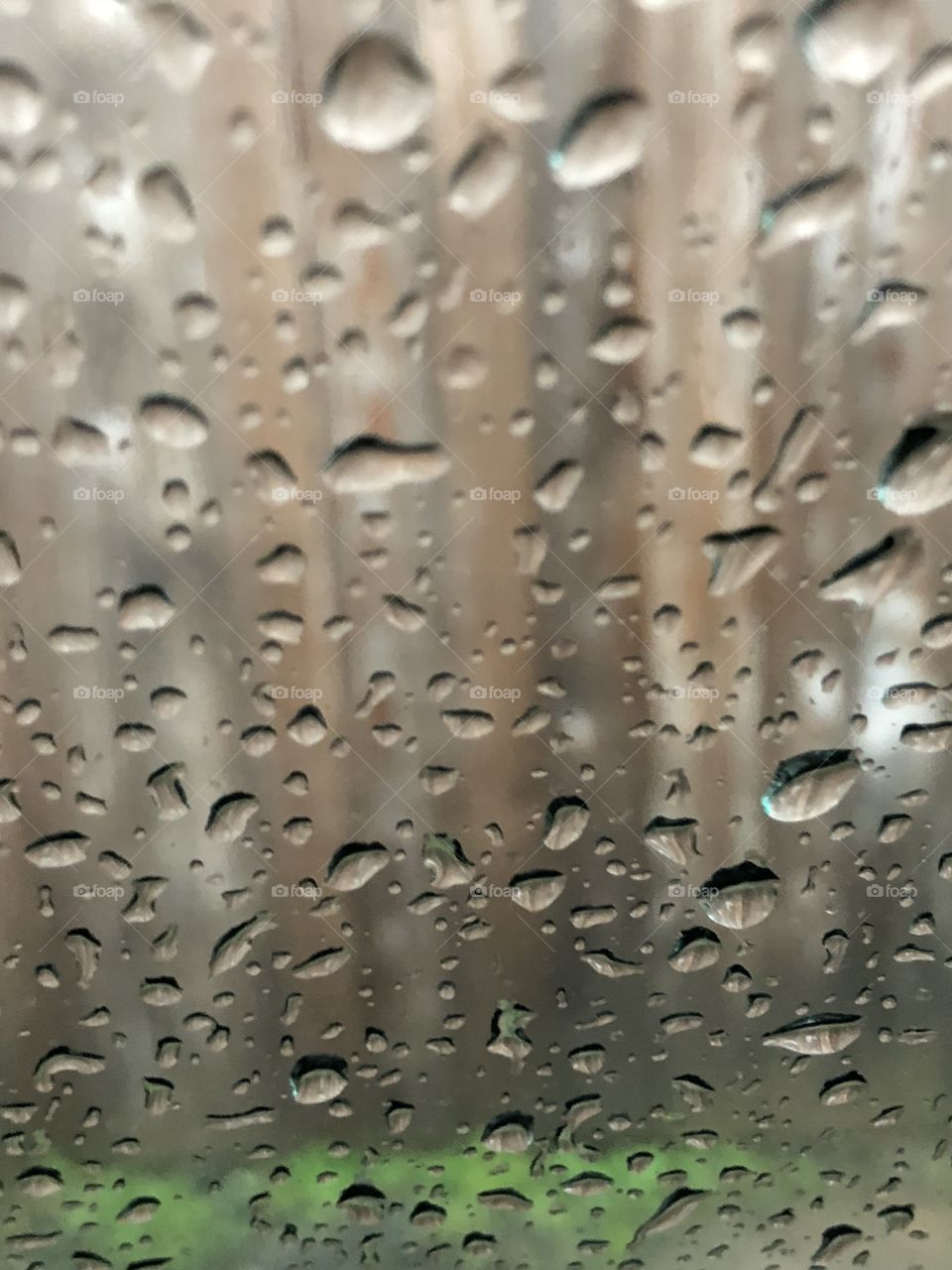 Raindrops on the window and fence behind. Beautiful clear drops. 