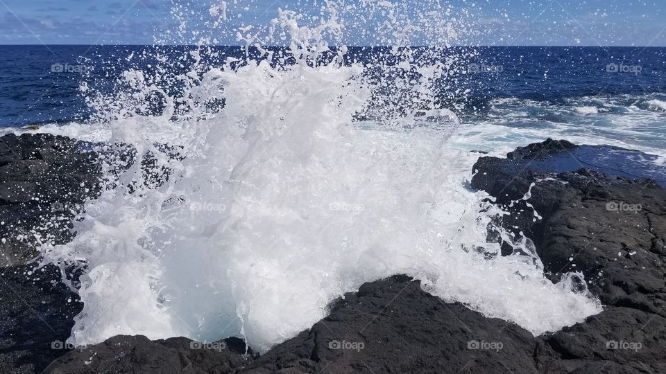 wave hitting lava rock