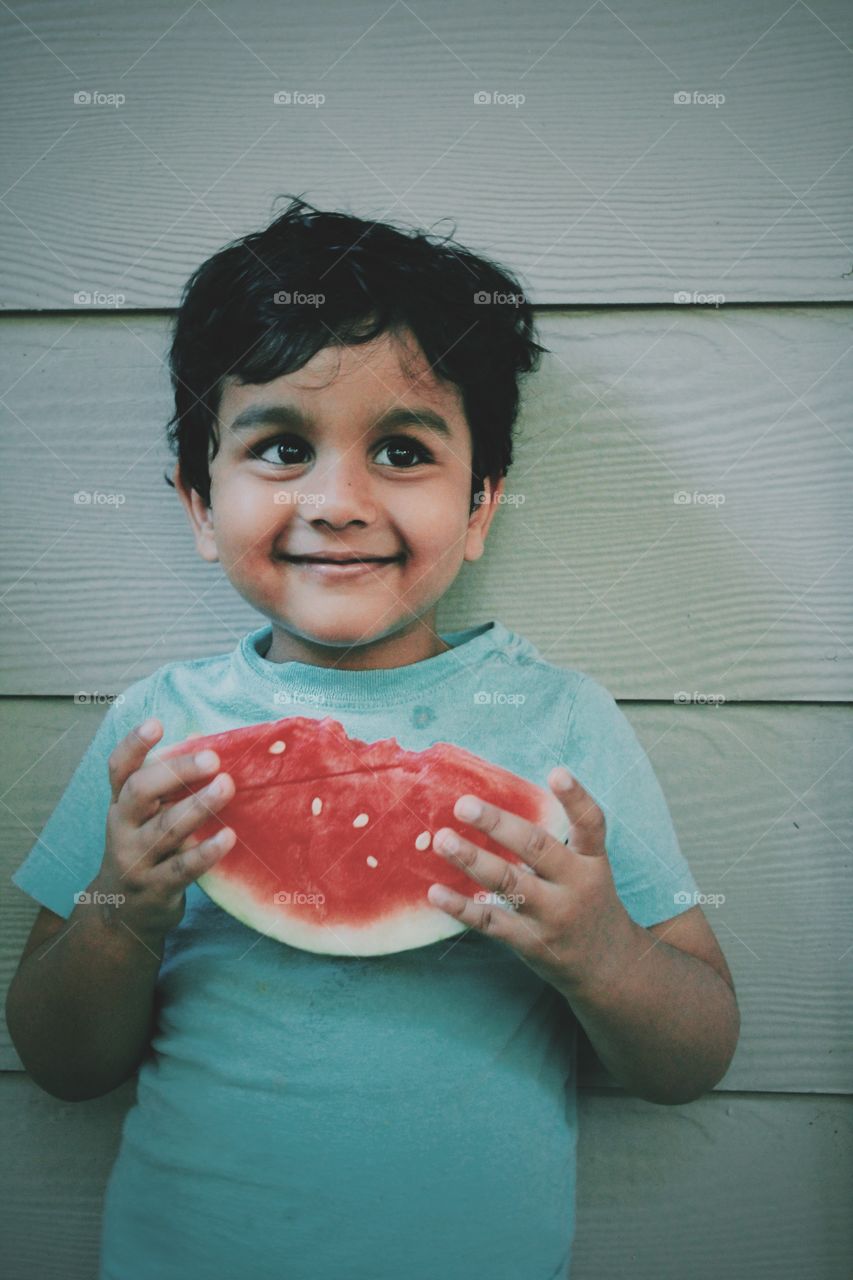 Cute boy holding watermelon in hand