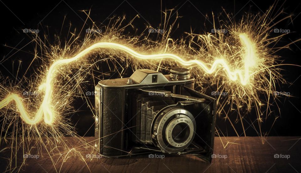 Vintage camera surrounded by sparks