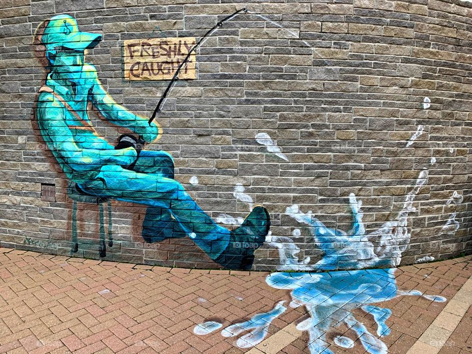 Fisherman - Visual Art that can be found on the street. Visual Street art is essentially synonymous with public art as it encompasses a variety of mediums like painting, sculpture, and stained glass