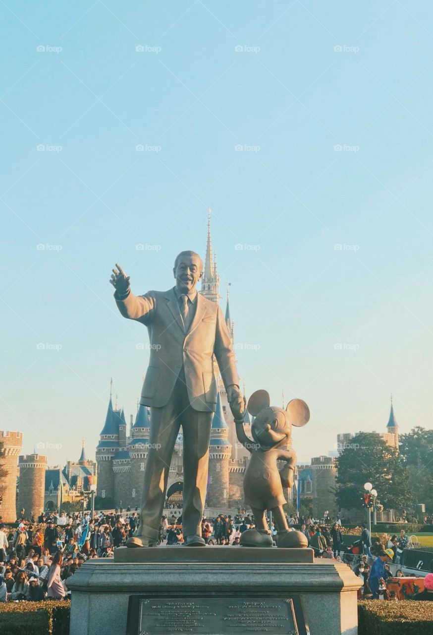 The statue of Mickey mouse and the man.