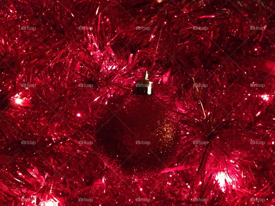 Red glitter ornament on red Christmas tree