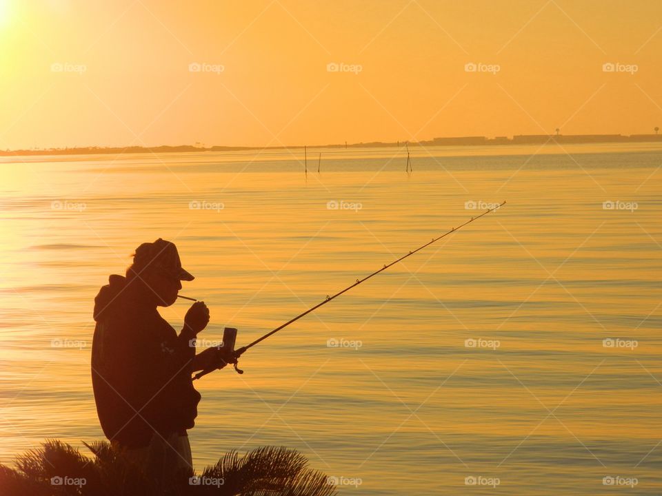 Man holding fishing net during sunset