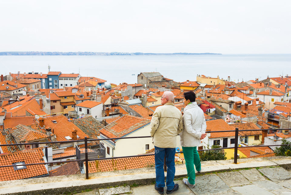 Piran view point, Slovenia. Tourist couple enjoying view of city of Piran, the famous coast city of Slovenia, Europe.