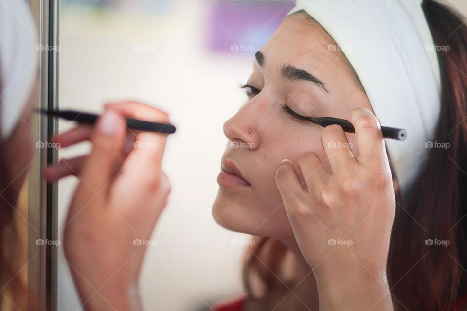 Woman is using an eye liner