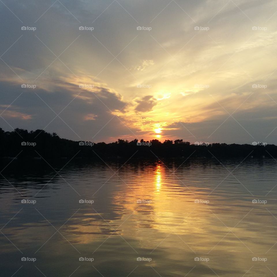 Sunlight falling on calm lake at sunset