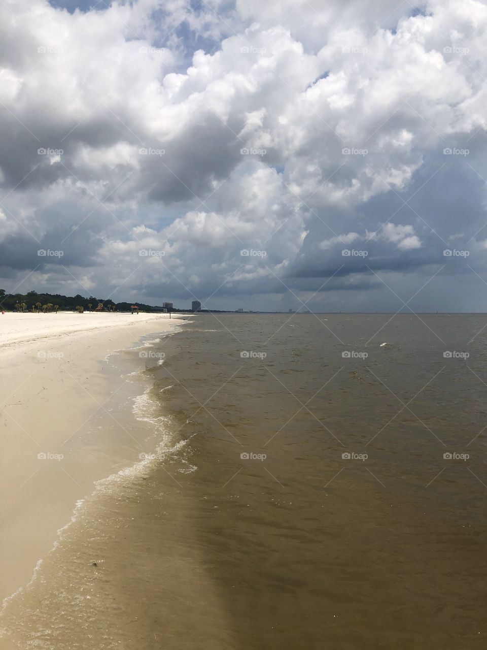 The Gulf waters and beach with stormy sky in Mississippi. 