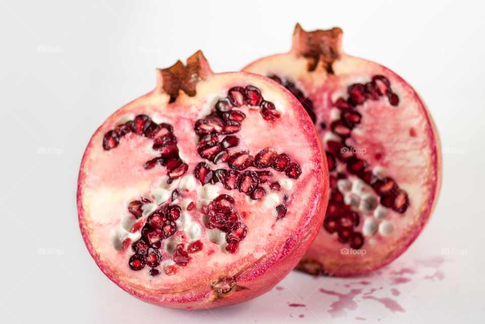 two halfs ripe pomegranate garnet fruit isolated on white background cutout