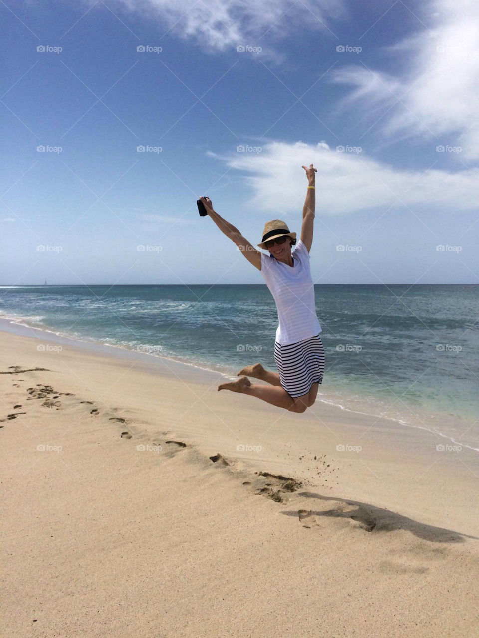 Woman jumping over the idyllic beach