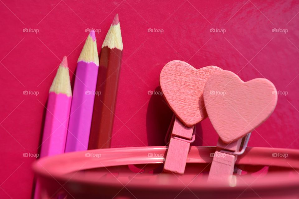 pink color wooden pencils and wood hearts pink background