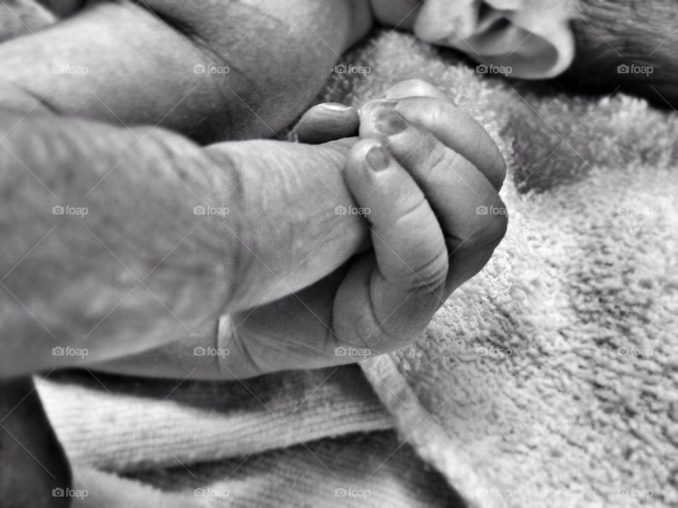 Son holding fathers finger for the first time