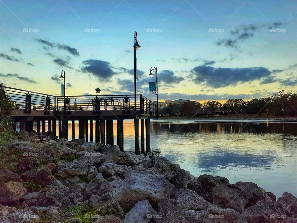 A beautiful sunset over the pier and Lake at Cranes Roost Park in Altamonte Springs, Florida.