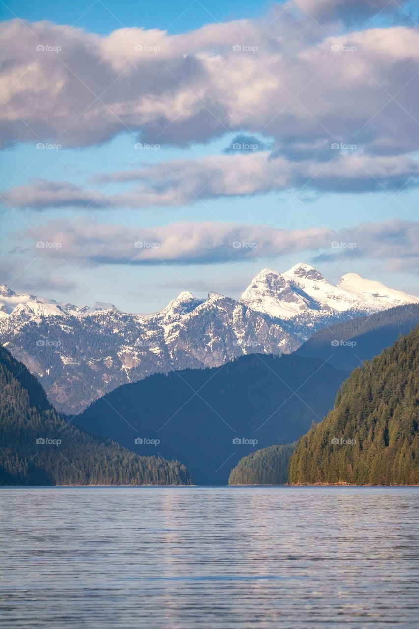 The end of snow capped mountains in the distance, with the landscape turning green as spring begins 