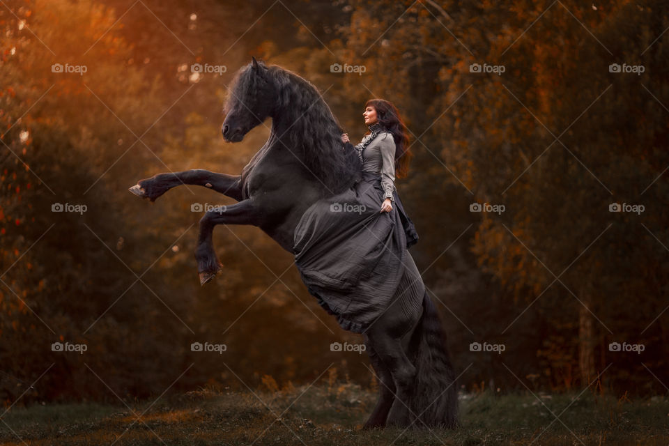 Beautiful young woman on black stallion 