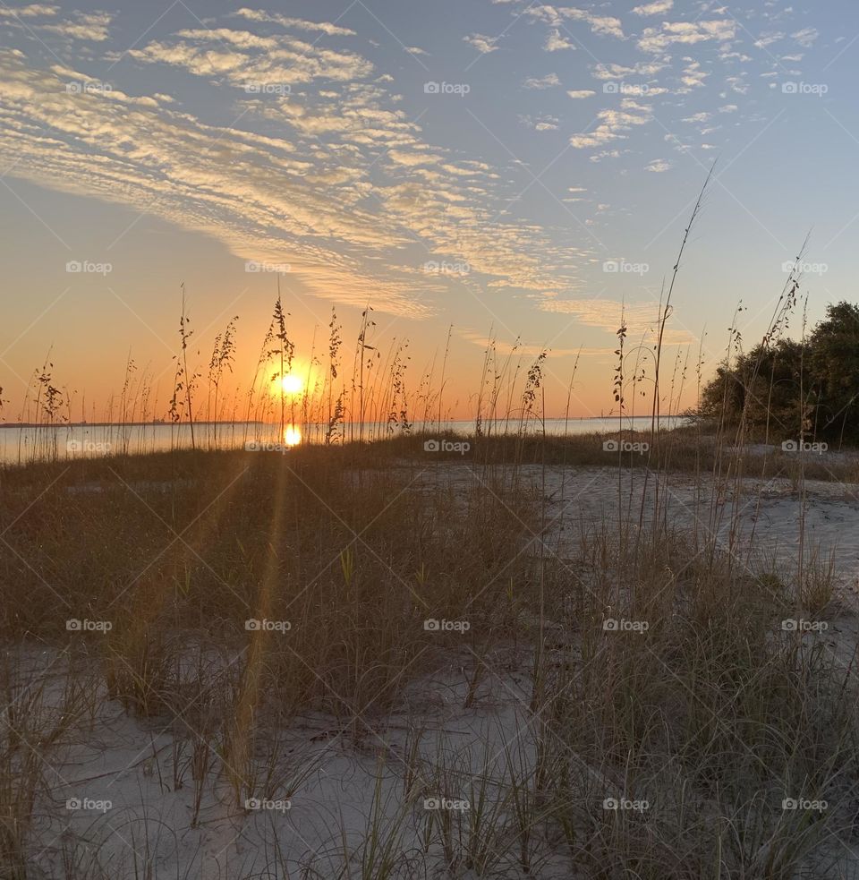 Walking through the sugary white sand and through the sea oats to catch the color of twilight and sunset. The dramatic hurried rush of orange collapses as the sun sinks below the gorgeous, colorful skyline