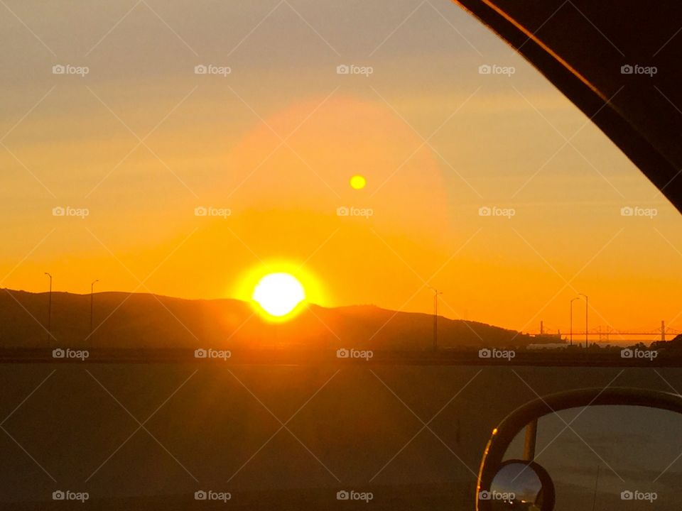 Enjoying the moon and sunset from moving car on highway 