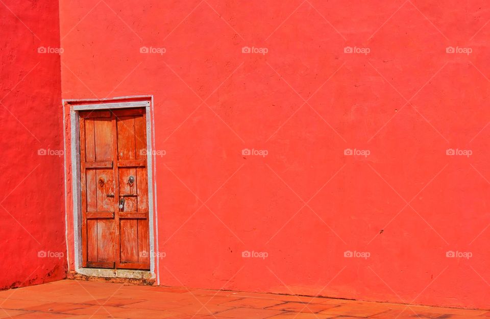 wooden door within brilliant red wall..