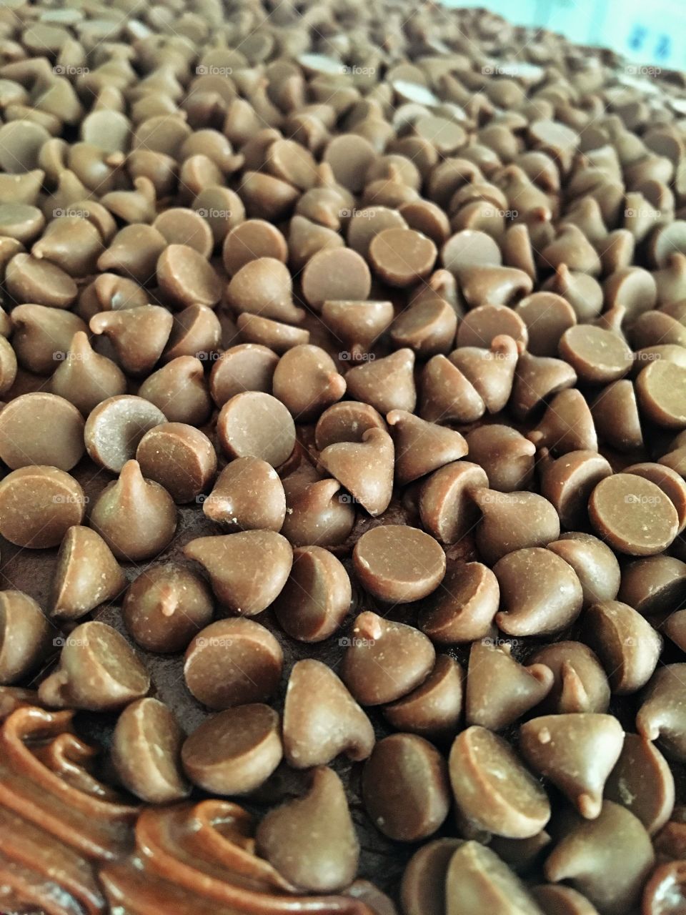 A sea of chocolate drops on top of a chocolate cake