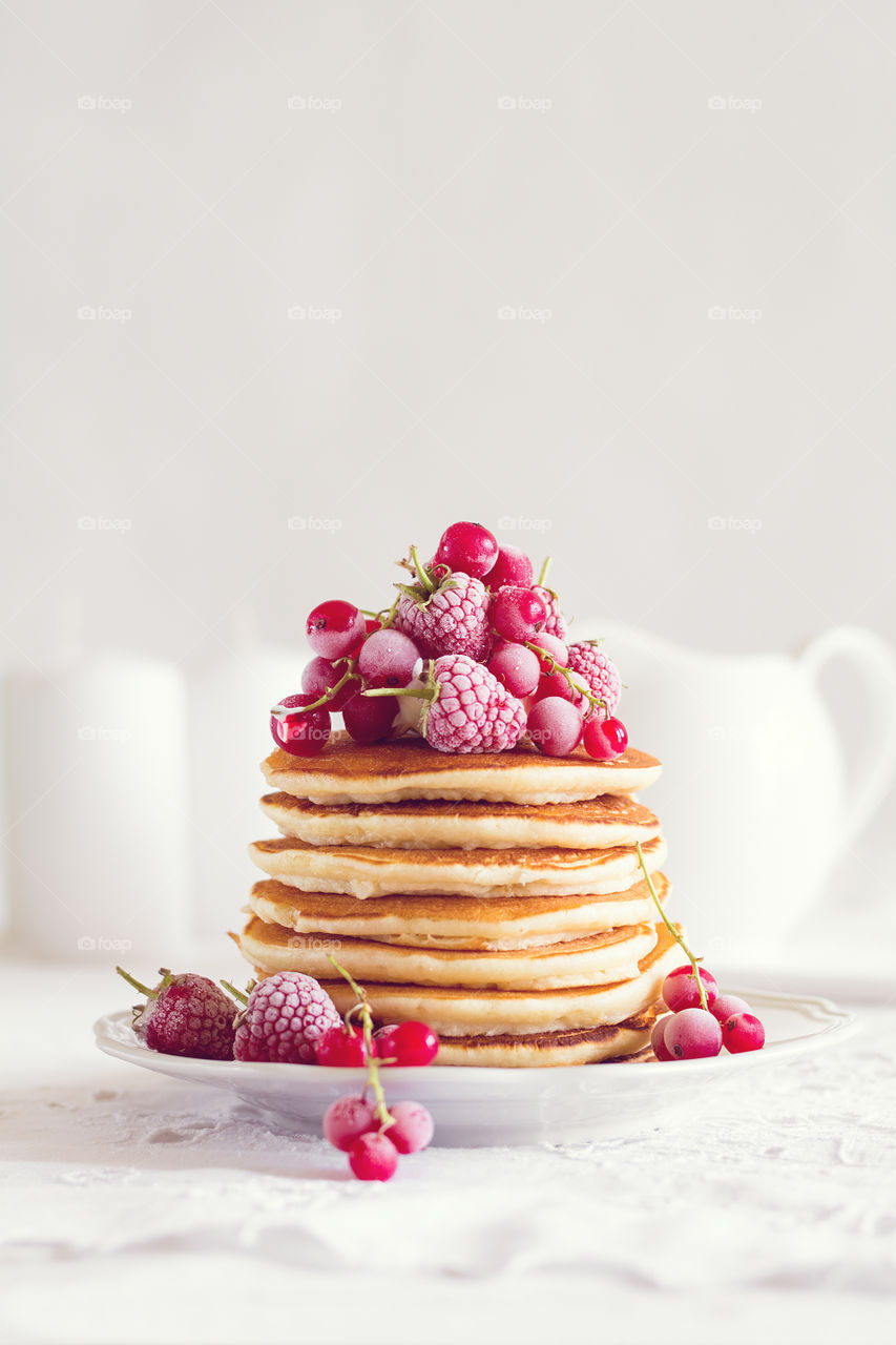 Stack of pancakes with frozen berries