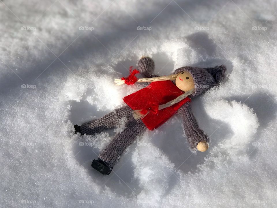 Wooden doll girl lies on the snow, scene game