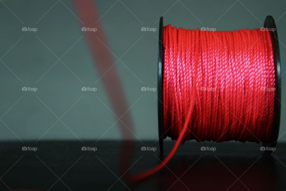 Close-up of a red mason's cord coiled on a spool