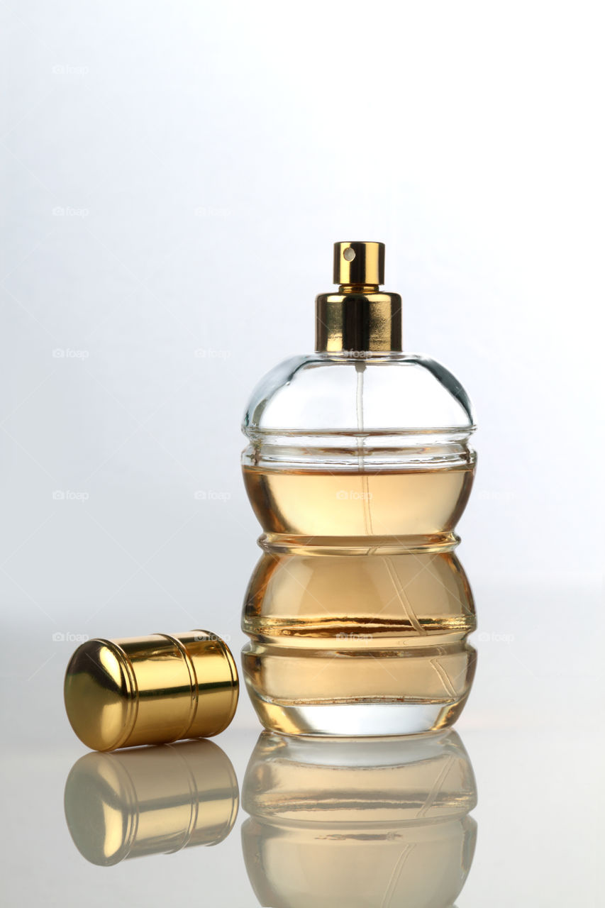 Beautiful Perfume bottle on white reflective background