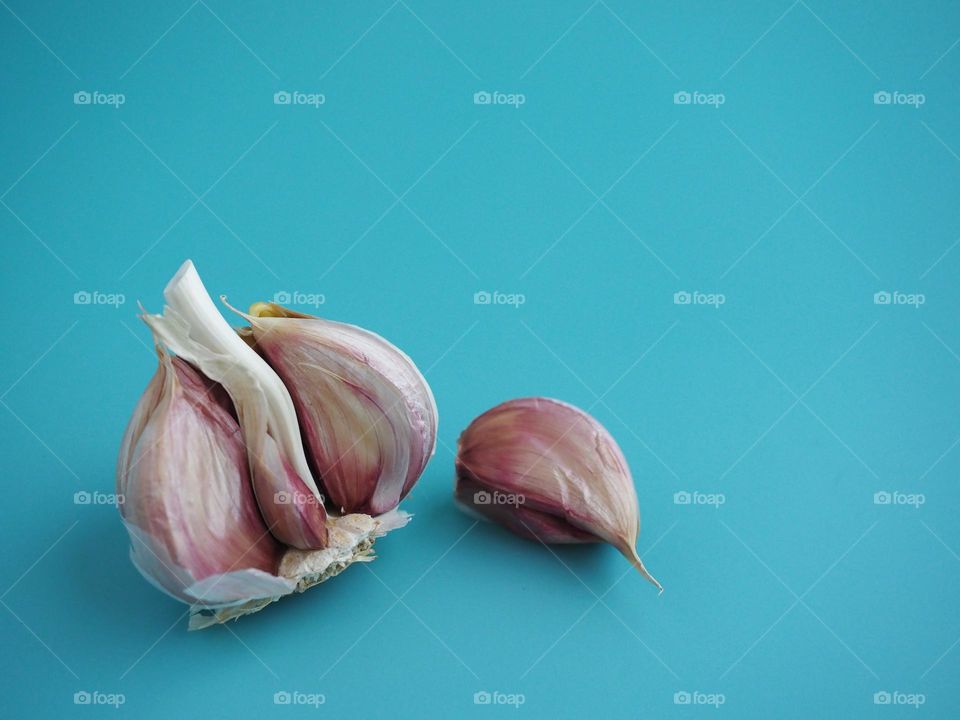 Half garlic and clove on blue bakcground