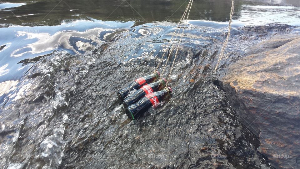 Coke on a rope in the slower part of the river.  keeping it cold