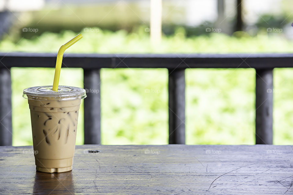 Iced coffee in a glass on the wooden table.