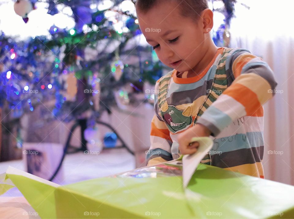 Happy kid unwrapping a Christmas present