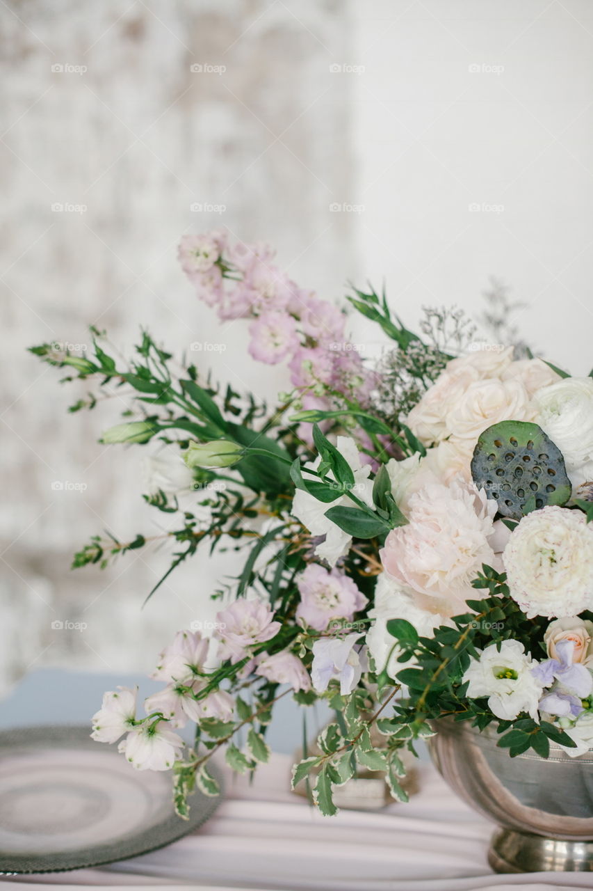 Flowers composition with cotton flower in silver bowl as a wedding decoration.