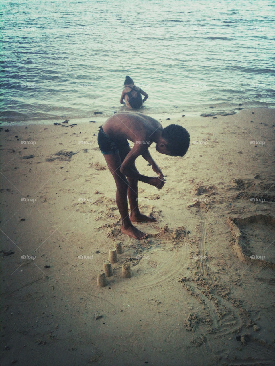 Boy building sandcastles on the beach.