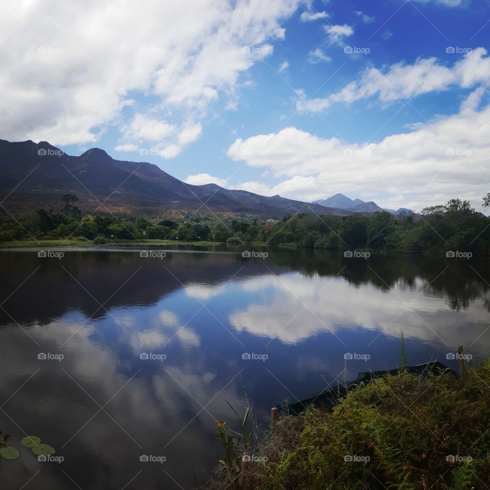 A perfect reflection of the cobalt blue skies and white clouds on the lake. peaceful and calming