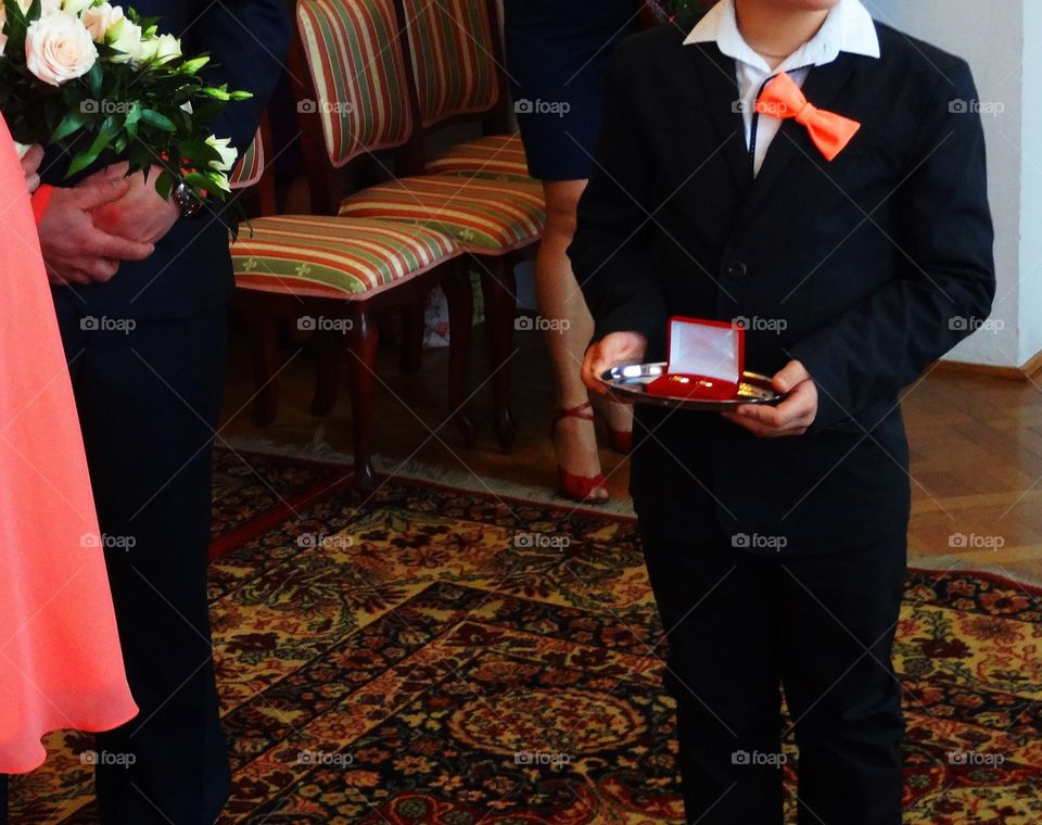 Boy holding weeding rings for his parents